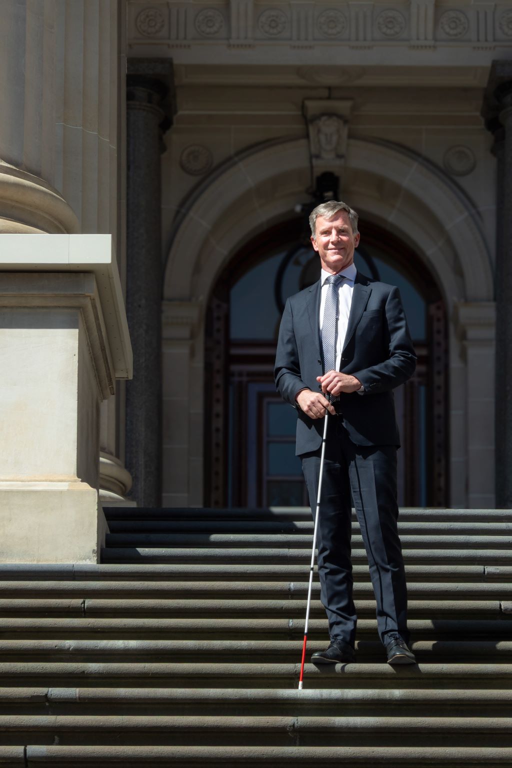 Full length image of Dan Stubbs standing outdoors on stone steps