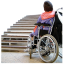 Woman in a wheelchair at the base of a flight of stairs
